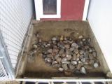 The first 2 loads we use small to medium sized river rock and then spread that out evenly in the kennel.